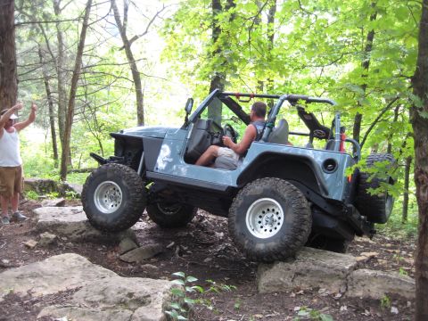 2005 Jeep Wrangler - 2005 Jeep Wrangler navigating a rocky off-road course in a wooded area.