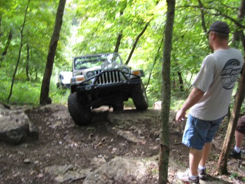 2005 Jeep Wrangler - A silver Jeep Wrangler tackles a challenging off-road course, with another vehicle visible in the background.