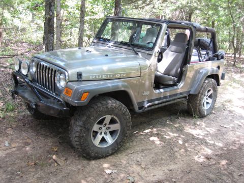 2005 Jeep Wrangler - A Jeep Wrangler Rubicon is parked on a dirt path surrounded by trees. The vehicle has its doors removed and top down.