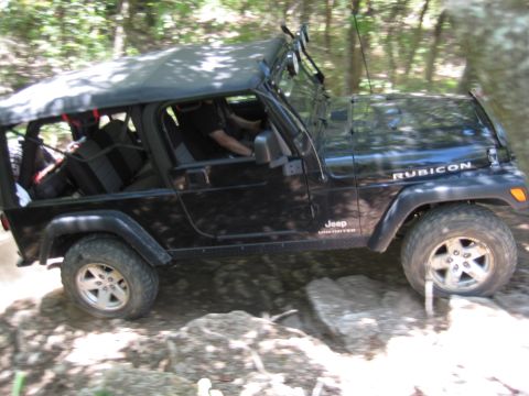 2005 Jeep Wrangler - A black Jeep Wrangler navigates a rocky trail, demonstrating its off-road capabilities.