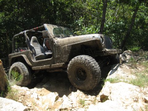 2005 Jeep Wrangler - 2005 Jeep Wrangler tackling a challenging off-road trail with mud and rocks.
