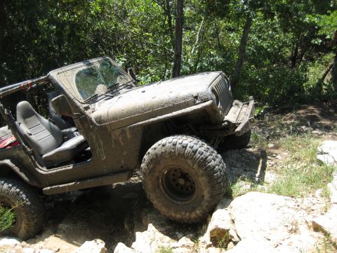 2005 Jeep Wrangler - This Jeep Wrangler is shown off-roading on a rocky trail, covered in mud.