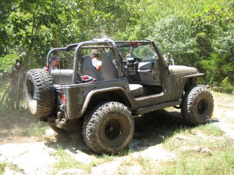 2005 Jeep Wrangler - This 2005 Jeep Wrangler is covered in mud as it navigates a rocky, off-road trail.