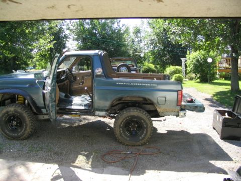 1986 Ford Bronco - Side view of a 1986 Ford Bronco with its doors off, parked in a driveway.