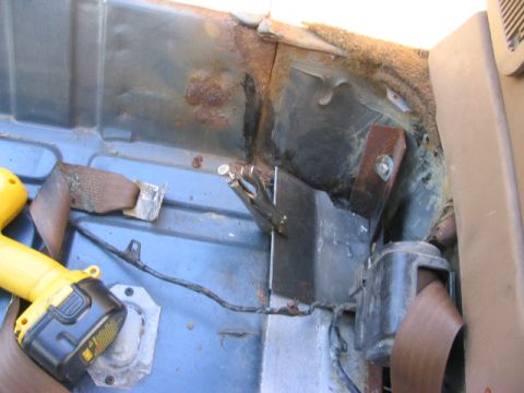 1986 Ford Bronco - The interior of the vehicle shows significant rust damage and some aftermarket modifications.