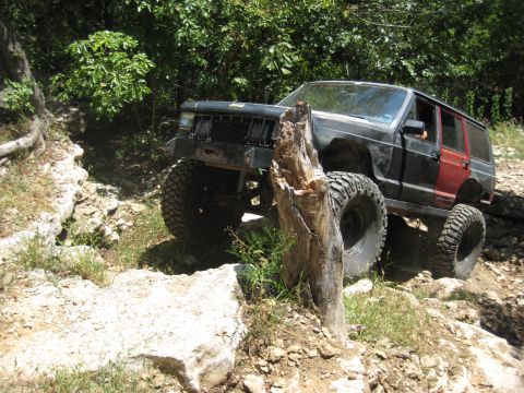 2005 Jeep Wrangler - A modified Jeep Cherokee XJ navigates a challenging off-road course with large tires and a lifted suspension.