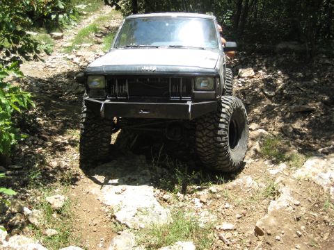 2005 Jeep Wrangler - Jeep Cherokee navigating a challenging rocky trail with significant tire articulation.