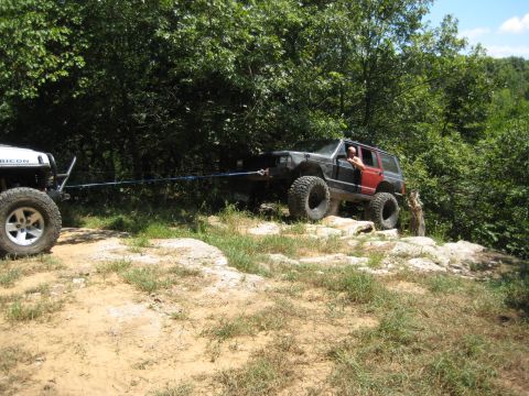 2005 Jeep Wrangler - Two Jeeps navigate a challenging off-road course, with one vehicle assisting the other.