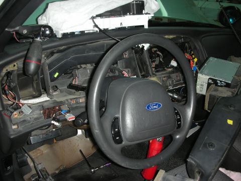 2004 Ford Crown Victoria - Dashboard disassembly in a 2004 Ford Crown Victoria, exposing wiring and components.