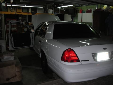2004 Ford Crown Victoria - White sedan with doors open and hood up, parked in a garage.