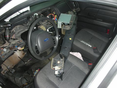2004 Ford Crown Victoria - The interior of a car is shown with the dashboard removed and various components exposed.