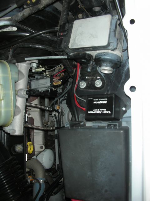 2004 Ford Crown Victoria - Close-up view of engine bay components including a tach adapter and fuse box.