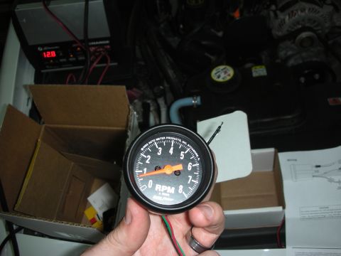 2004 Ford Crown Victoria - Installing an Auto Meter tachometer gauge, with wiring and instructions nearby.