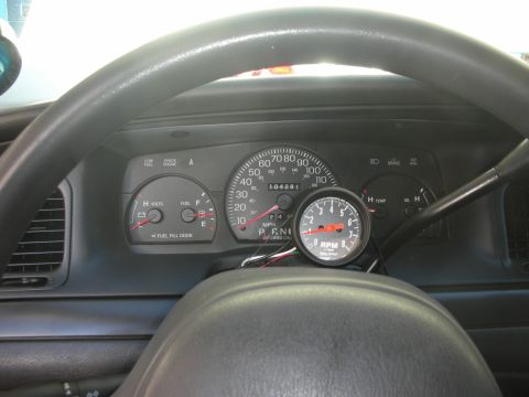 2004 Ford Crown Victoria - Aftermarket tachometer installed on the dashboard of a 2004 Ford Crown Victoria, showing 104,281 miles on the odometer.
