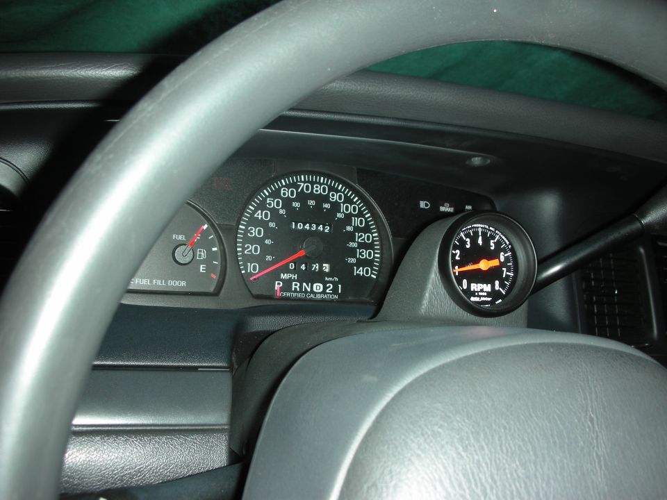 2004 Ford Crown Victoria dashboard showing speedometer, fuel gauge, and aftermarket tachometer