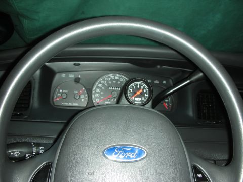 2004 Ford Crown Victoria - Driver's-eye view of a gray Ford instrument cluster shot through the steering wheel, showing an odometer reading of 104342 miles, speedomet…