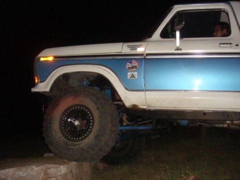1992 Ford Bronco - A modified Ford Bronco with a two-tone paint job and large tires is shown from the front quarter angle.