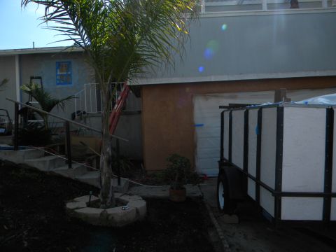 1992 Ford Bronco - A white enclosed trailer is parked next to a garage door.