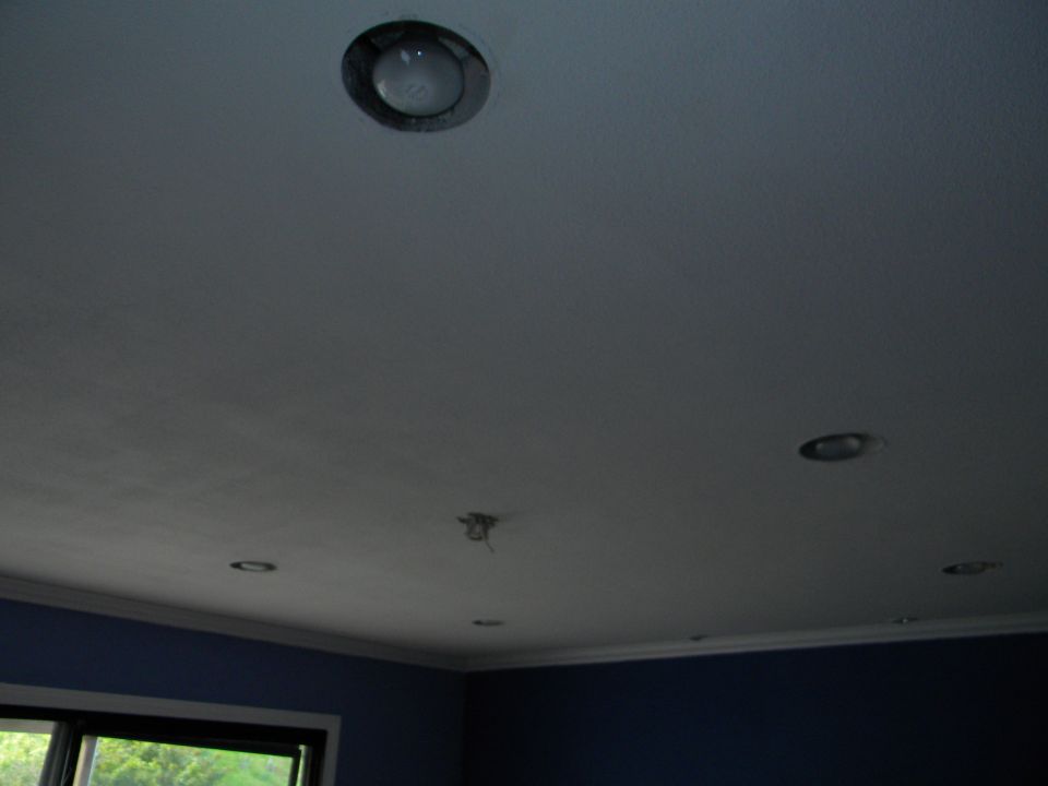 Recessed ceiling lights in a room with blue walls and a window