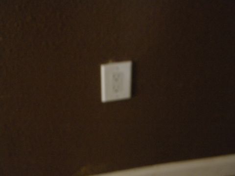 1992 Ford Bronco - An electrical outlet is visible on a dark brown wall, with a website watermark at the bottom right.