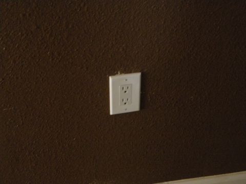 1992 Ford Bronco - An electrical outlet is mounted on a brown textured wall.