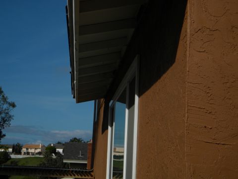 1992 Ford Bronco - Residential buildings and sky are visible under a house's eaves.