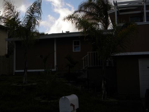 1992 Ford Bronco - A residential scene a house, palm trees, and a mailbox under a cloudy sky.