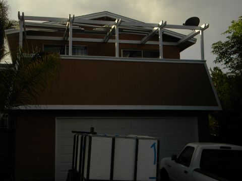 1992 Ford Bronco - A house with a garage door, a trailer carrying white boxes, and a white truck are visible under a cloudy sky.