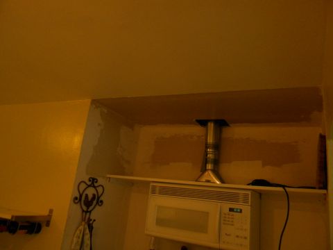 1992 Ford Bronco - A microwave oven is visible on a shelf, with a metal vent pipe extending upwards.