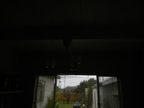 1992 Ford Bronco - View from inside a dark room through a sliding glass door to a residential backyard.