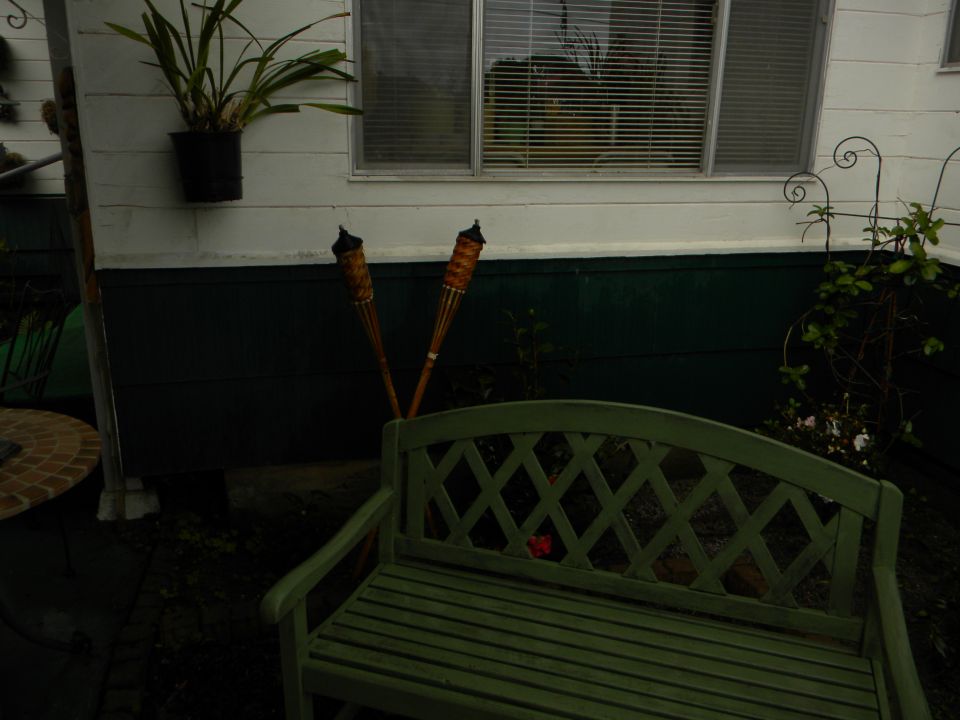 Patio scene with green bench and tiki torches