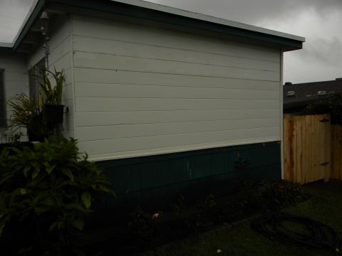 1992 Ford Bronco - Exterior view of a house showing siding, plants, and a wooden fence under an overcast sky.