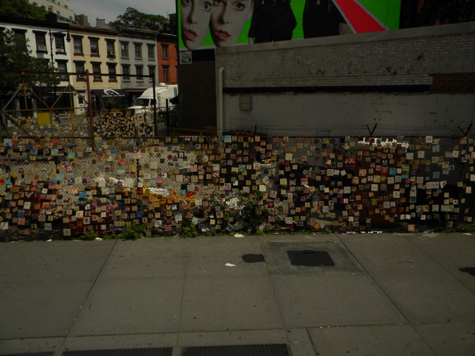 White van behind a chain-link fence decorated with numerous small squares