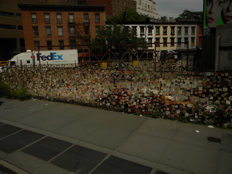 FedEx truck parked behind a chain-link fence covered in many small, colorful squares