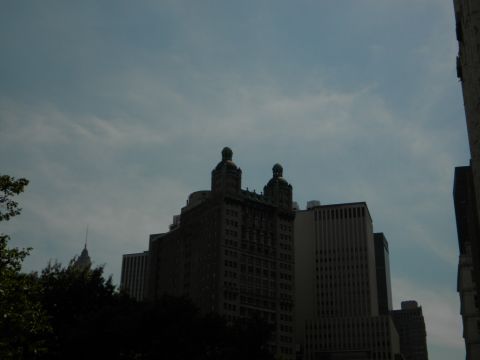1992 Ford Bronco - A cityscape scene with multiple buildings under a cloudy sky, a website logo at the bottom right.