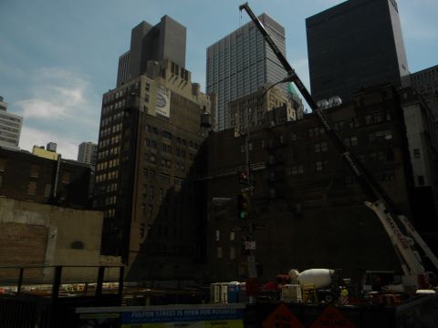 1992 Ford Bronco - A construction site is active with a crane and cement mixer against a backdrop of city buildings.