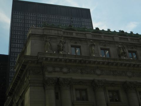 1992 Ford Bronco - A view of an ornate building facade statues and architectural details, with a modern skyscraper in the background under a cloudy sky.