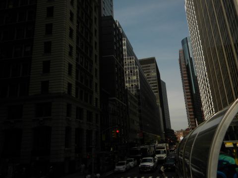 1992 Ford Bronco - A white SUV is seen on a city street surrounded by tall buildings.