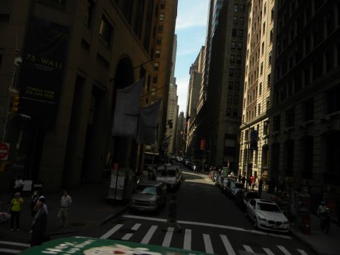 1992 Ford Bronco - A view down a city street lined with tall buildings, with several cars parked along the side.