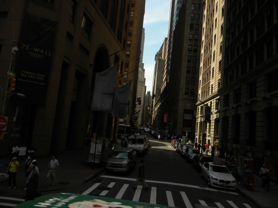 Street view of tall buildings and parked cars on a sunny day