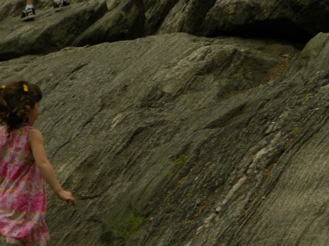 1992 Ford Bronco - A young girl explores a rocky landscape, with two people's legs visible above.