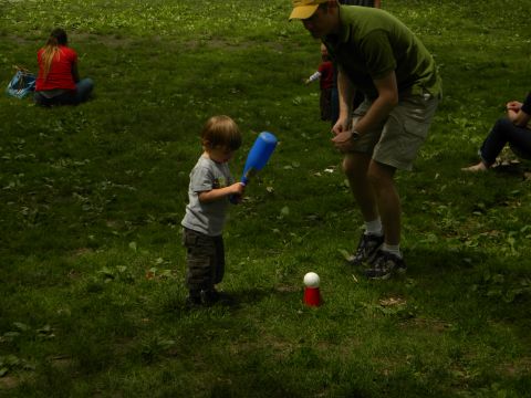 1992 Ford Bronco - A child practices hitting a ball off a tee with a blue bat while an adult supervises in a grassy park setting.