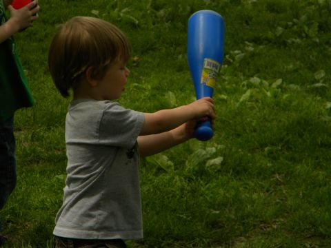 1992 Ford Bronco - A young child holds a blue toy bat in a grassy outdoor area.