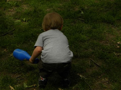 1992 Ford Bronco - A young child is seen from behind, holding a blue toy in a grassy outdoor setting.