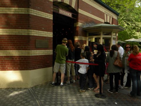 1992 Ford Bronco - A group of people wait in line outside a building with an 'ENTRANCE' sign.