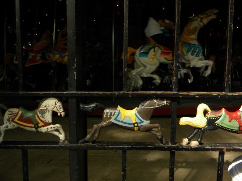 1992 Ford Bronco - A row of carousel horses are visible behind a dark fence, with some horses in the background also visible.