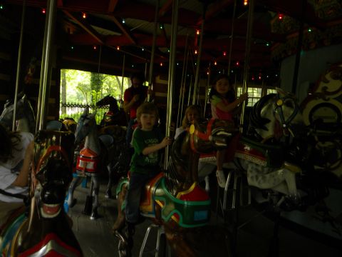 1992 Ford Bronco - Children enjoy a ride on carousel horses, with the Supermotors.net logo visible in the lower right corner.
