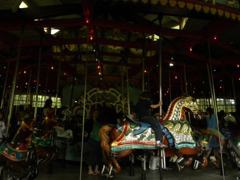 1992 Ford Bronco - A carousel with several horses and riders is shown inside a building with decorative lights.