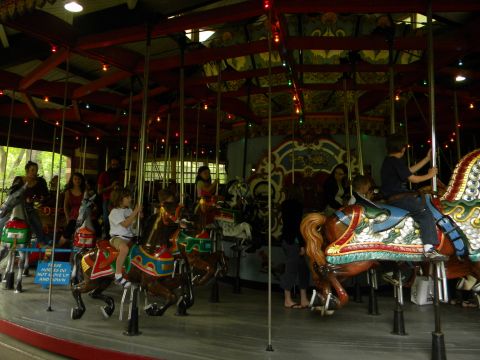 1992 Ford Bronco - A carousel scene with people riding on decorated horses, set under a covered pavilion.
