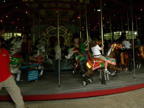 1992 Ford Bronco - Children enjoy a ride on a carousel, with various painted horses in motion.